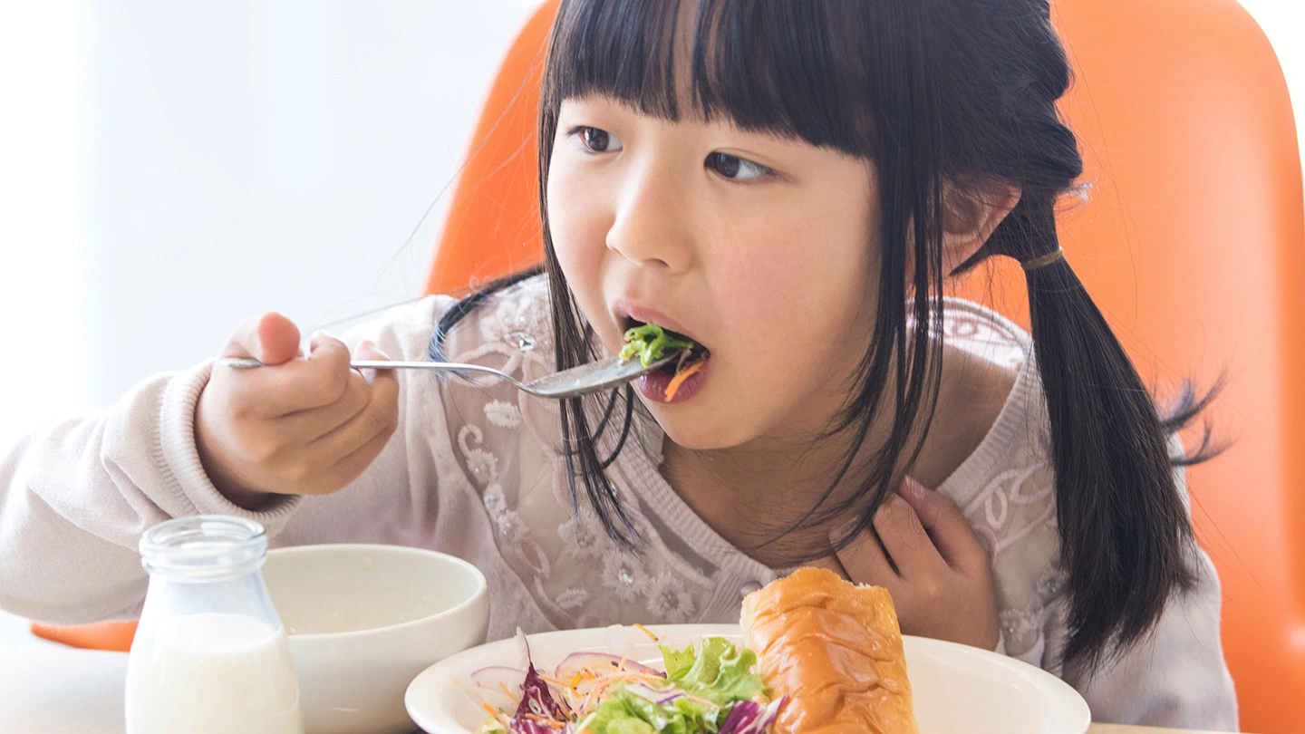 給食を食べる小学生
